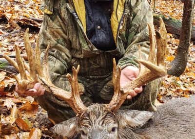 Old smiling hunter with large buck